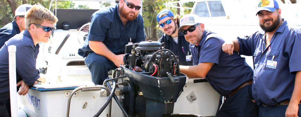 FMTC students work on an outboard motor